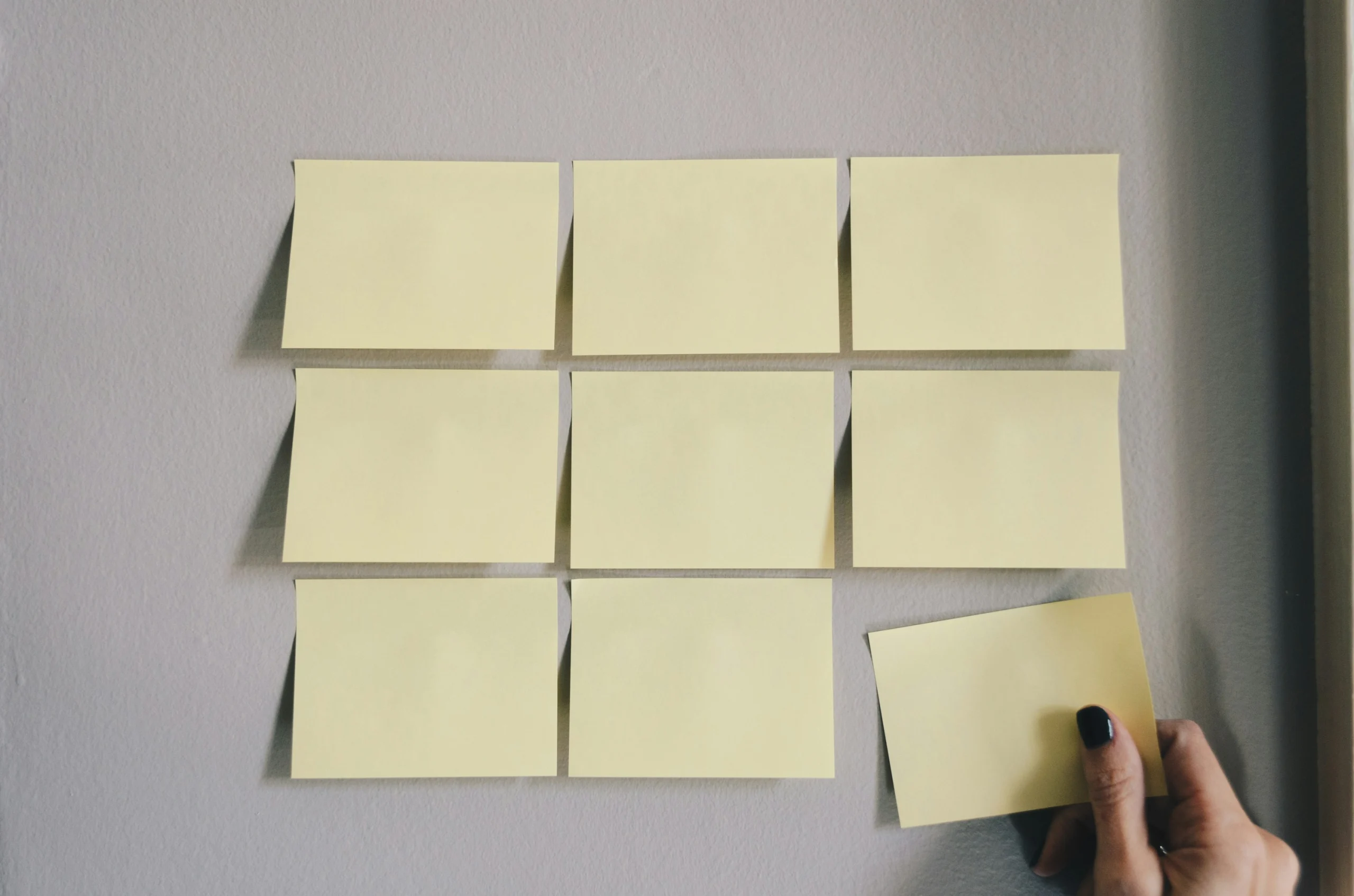 Sticky notes arranged in a grid on a wall, representing workflow planning and batch organisation of ecommerce product images.